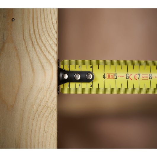 STANLEY 0-33-728 tape measure close-up on wood, yellow color with clear metric markings.