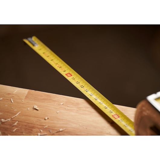 STANLEY 0-33-932 yellow tape measure photography, close-up on wooden surface.