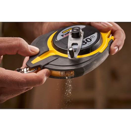 Photo of STANLEY 0-34-134 tape measure with yellow and black casing, chalk being dispensed during use.
