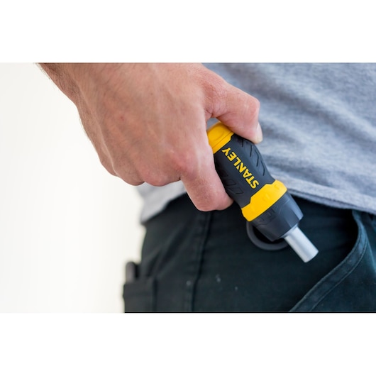 Photo of STANLEY 0-66-358 screwdriver with yellow and black handle held in hand near pocket.