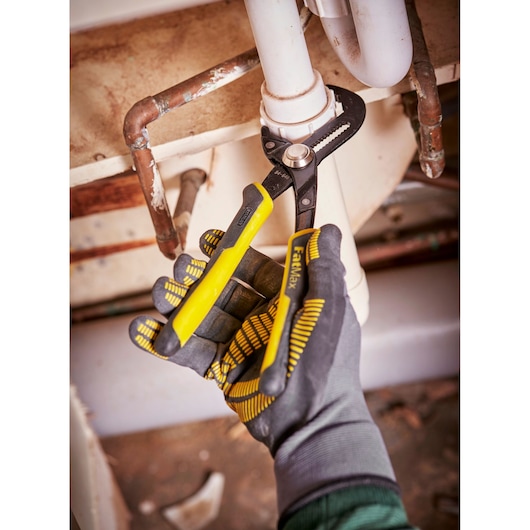 STANLEY 0-84-648 pliers with yellow handles used for plumbing under sink, close-up photography.