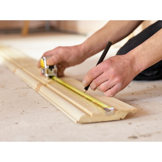 STANLEY 1-33-198 tape measure photography showing measuring and marking wood plank.