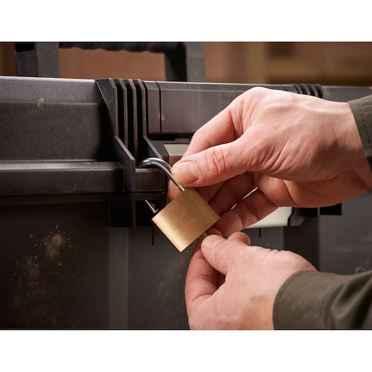 STANLEY 1-97-510 photography of hands locking black tool box with brass padlock.