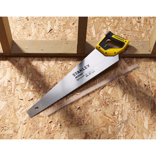 STANLEY 2-15-244 hand saw with yellow handle on plywood surface, photography category.