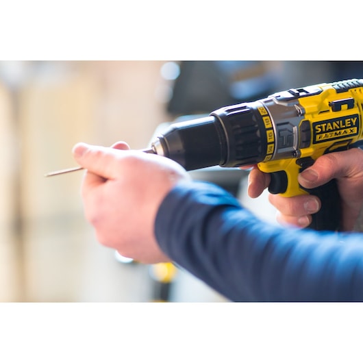 Photo of STANLEY FMC625D2 cordless drill being used, with close-up on hand inserting drill bit.