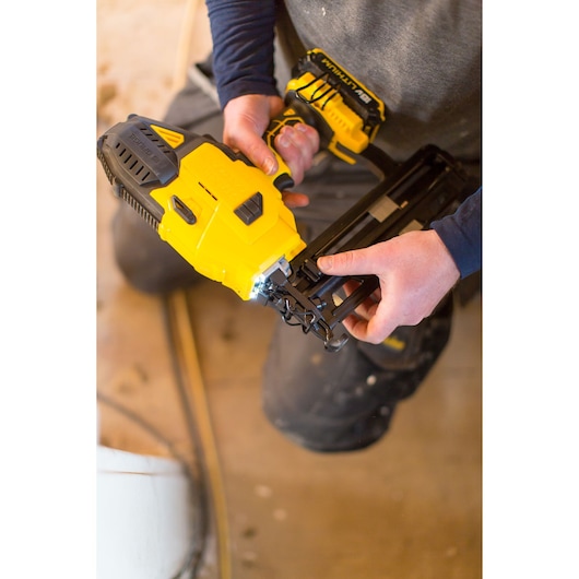 STANLEY FMC792B cordless nail gun in use, yellow and black design, handheld on work site.