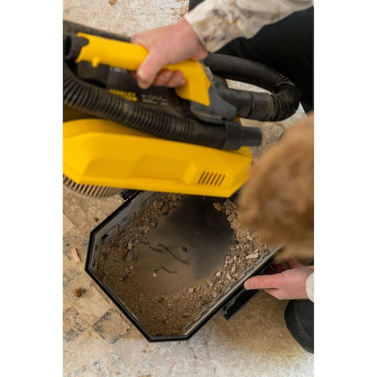 STANLEY FMC795B vacuum cleaner with open dust container showing collected debris, photo from above.