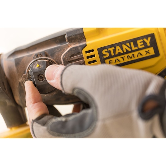 Photo of STANLEY FMCD900M2S tool selector switch being adjusted, yellow and black casing, close-up angle.