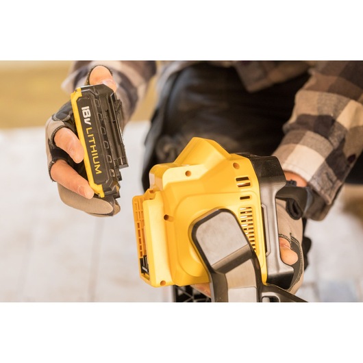 STANLEY FMCL001B cordless tool with 18V lithium battery held by a gloved hand, close-up photography.