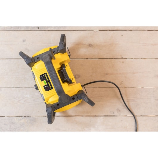 Photo of STANLEY FMCR001B yellow and black jobsite radio on wood floor, top view.