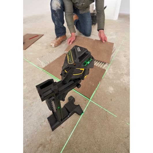 STANLEY FMHT1-77356 laser level projecting green lines on floor, used for tile alignment during installation.