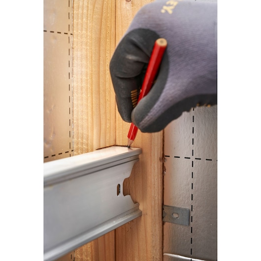 STANLEY FMHT43680-1 photography of gloved hand marking wood with red pencil near metal rail.