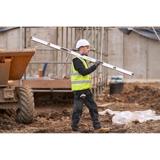 STANLEY FMHT43680-1 spirit level carried by construction worker in safety gear at building site.