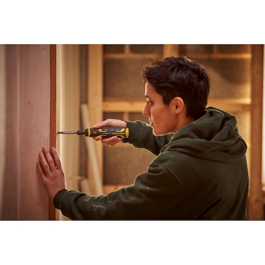 Stanley FMHT66719-0 electric screwdriver used by a person in a workshop setting.