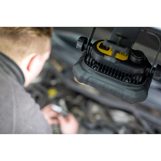STANLEY FMHT81507-1 work light in use above car engine, close-up photography.