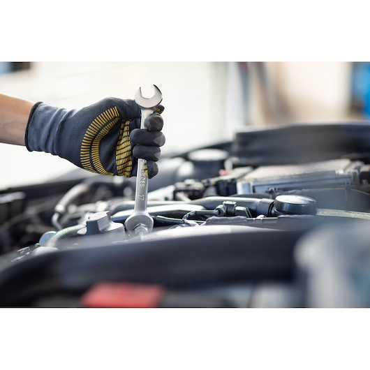 Photo of STANLEY FMMT13074-0 wrench in gloved hand, working on car engine, product category Photography.