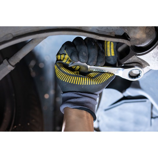 STANLEY FMMT13097-0 ratcheting wrench tool in use by gloved hand working on machinery.