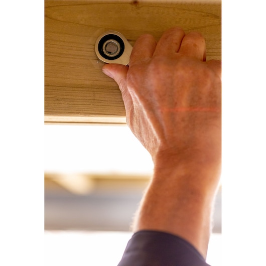 Photo of hand using STANLEY FMMT13111-0 ratchet wrench on bolt in wood beam.
