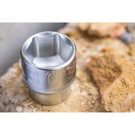 STANLEY FMMT17220-0 socket tool from side, silver hex design, resting on rough concrete surface.