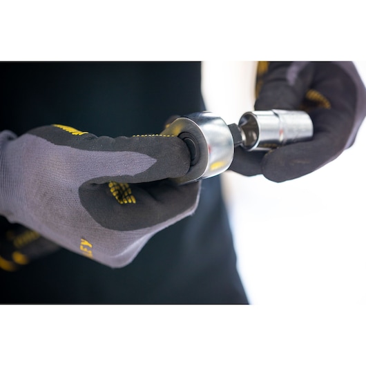 Photo of a STANLEY FMMT17231-0 socket tool held by gloved hands, close-up view.