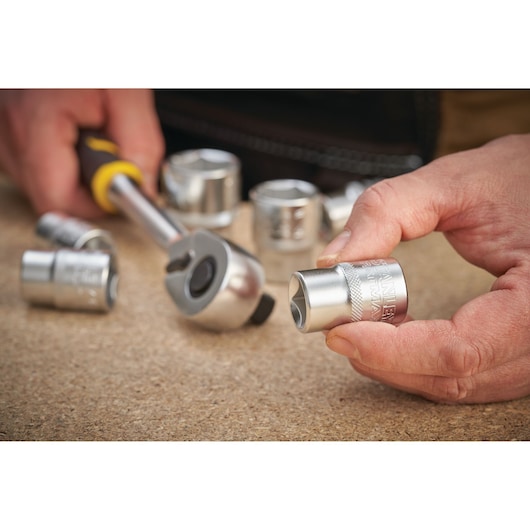 STANLEY FMMT17232-0 socket with ratchet tool held by hand, silver finish, close-up photography.