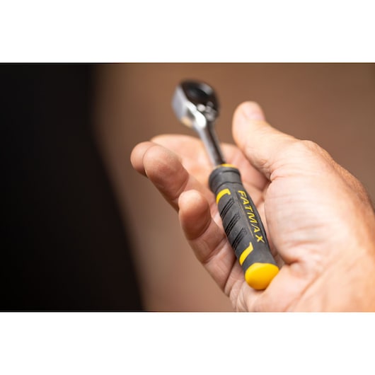 STANLEY FMMT82676-0 ratchet with black and yellow FATMAX handle held in hand, close-up.
