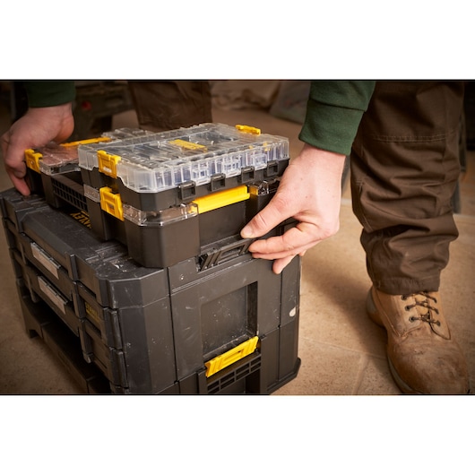 STANLEY FMMT98101-0 photography of modular black and yellow toolboxes being latched together from a side angle.