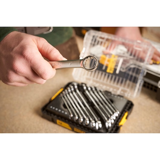 STANLEY FMMT98104-0 combination wrench held above wrench set in black and yellow case, close-up photo.