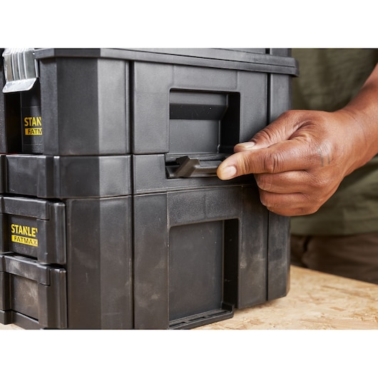 Photo of STANLEY FMST1-71981 black tool box being latched by hand, close-up view.