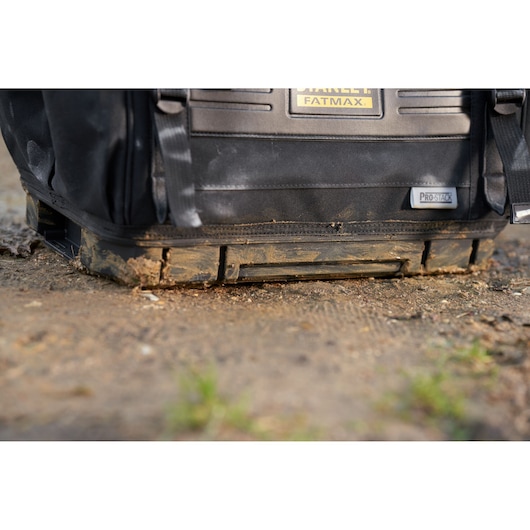STANLEY FMST17627-1 tool bag with Pro-Stack base on ground, close-up shows dirt on durable bottom.