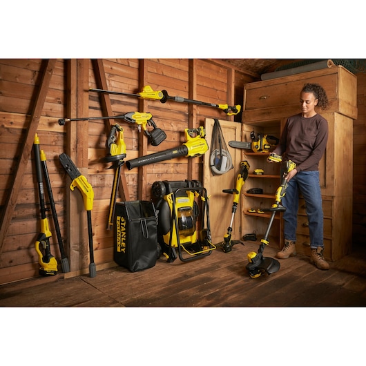STANLEY SFMCCS630B garden power tools displayed in shed, including trimmer, blower, and accessories.