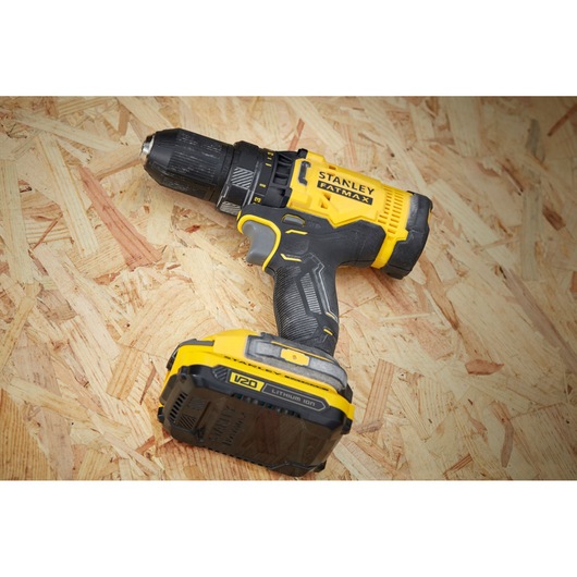 STANLEY SFMCD700C2S cordless drill driver with yellow and black body, shown on wooden surface.