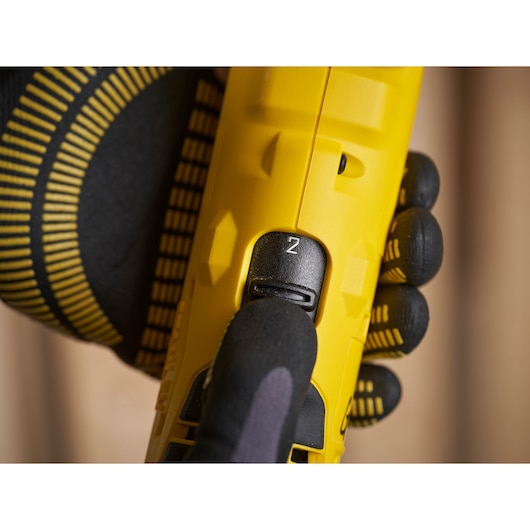 Photo of STANLEY SFMCD750B drill speed switch, close-up, with gloved hand adjusting control.