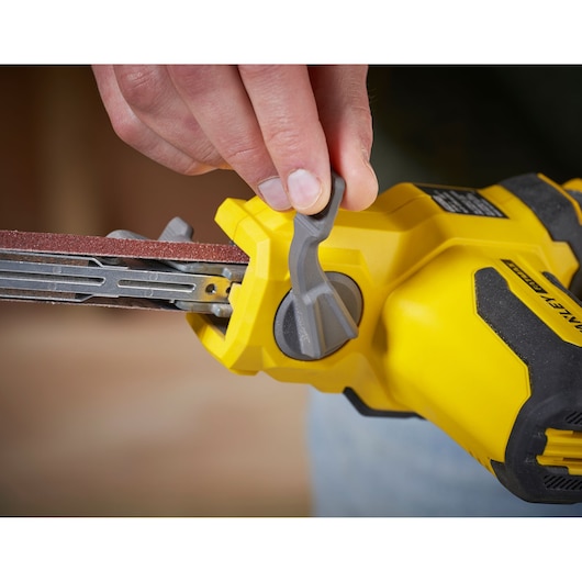 Stanley SFMCE210D2 photography close-up of yellow cordless belt sander with hand adjusting lever.