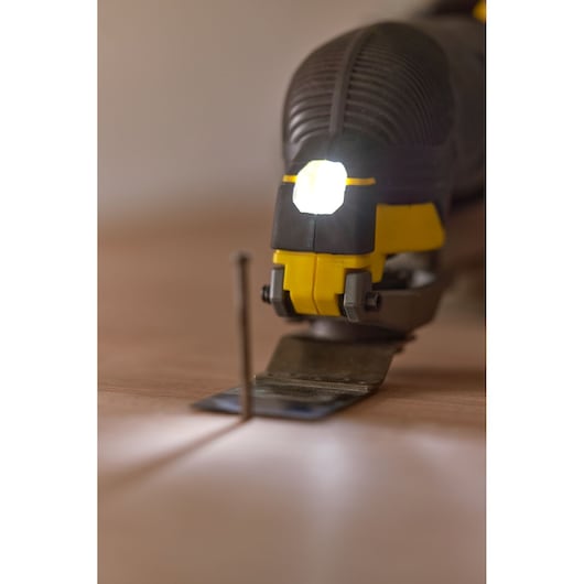 STANLEY SFMCE500B oscillating multi-tool with LED light, close-up on flat surface, blade facing forward.