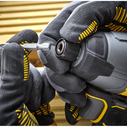 STANLEY SFMCF800C2K impact driver close-up with gloved hands inserting a bit, power tool photography.