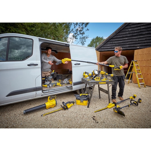 STANLEY SFMCHT855B garden tools displayed near van, including hedge trimmers, blower, and pole saw.
