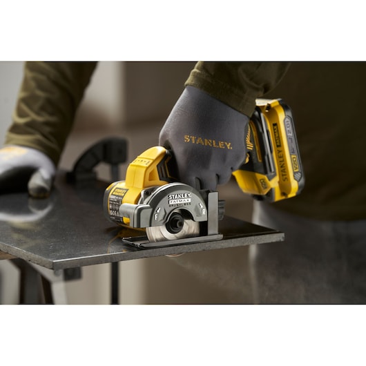 STANLEY SFMCM300D2 compact cordless circular saw cutting metal, close-up action shot.
