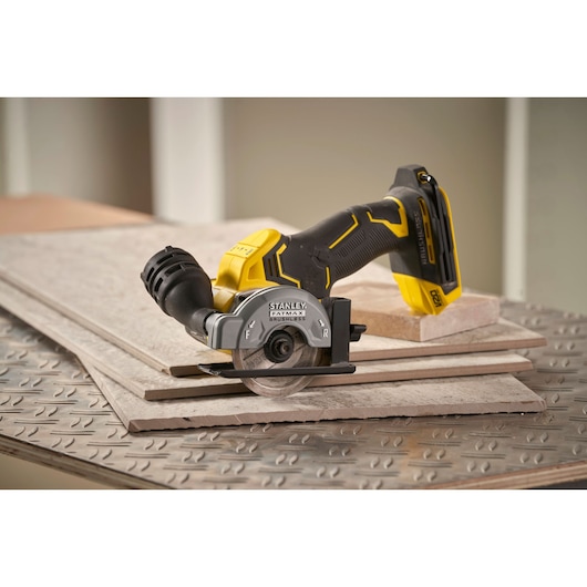 STANLEY SFMCM300D2 cordless tile saw on ceramic tiles, photography showing side angle.