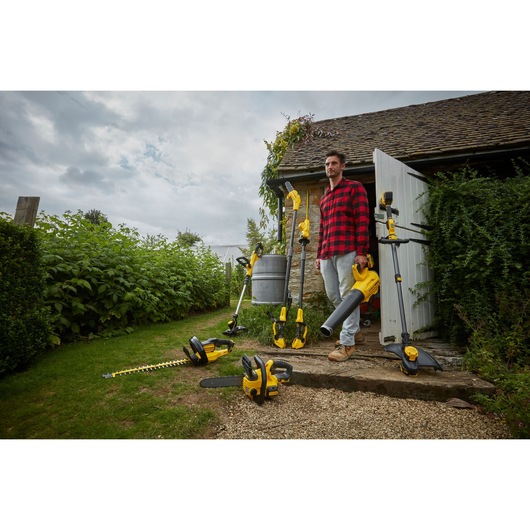 Stanley SFMCPS620B garden power tools displayed outdoors near a house, various yellow and black tools shown.