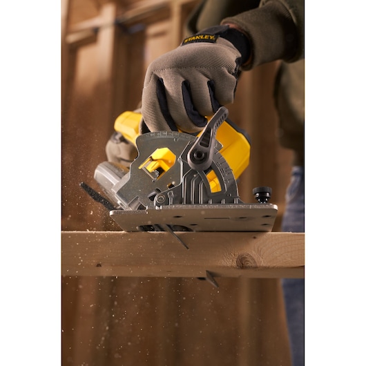 STANLEY SFMCS500B circular saw cutting wood, side angle, yellow and metal design, construction setting.