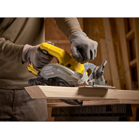 STANLEY SFMCS550M2K circular saw in use cutting wood, yellow and gray body, close-up photography.