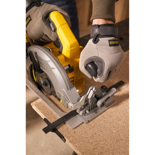 STANLEY SFMCS550M2K circular saw in use cutting wood, close-up from side angle, gloves worn.