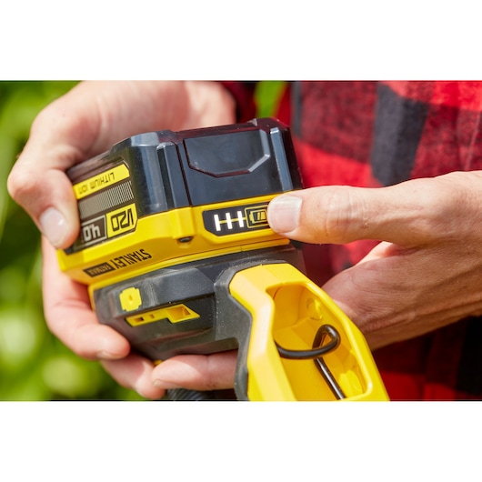 Photo of STANLEY SFMCST933B cordless tool battery in close-up, showing battery level indicator and yellow handle.