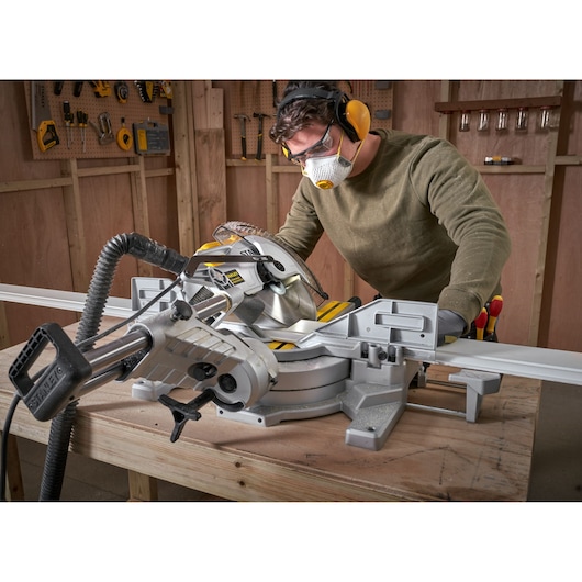 STANLEY SM1800 sliding compound miter saw in use on wooden workbench in workshop setting.