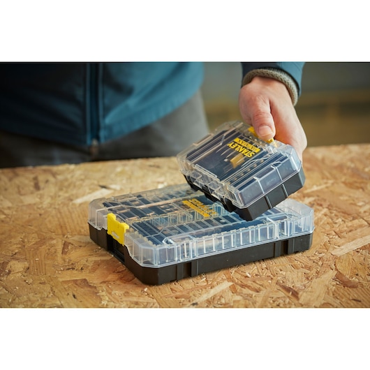 STANLEY STA88556 clear plastic organizer box with removable compartment, on wooden surface.