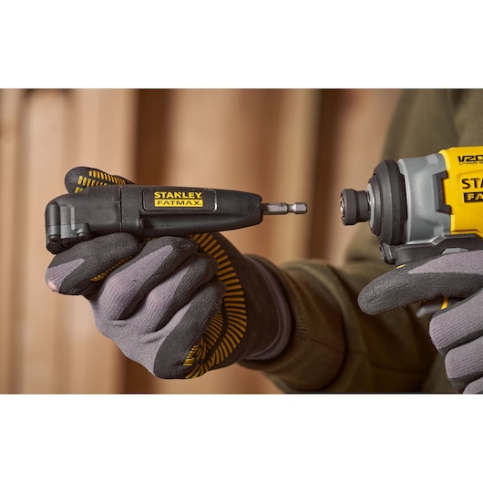 Stanley STA88582 right angle drill attachment in hand, close-up, with Fatmax branding visible.
