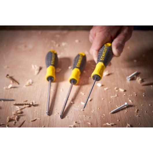 STANLEY STHT0-60358 screwdriver set with yellow and black handles on a wood surface with screws and shavings.