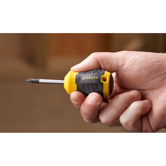 Stanley STHT16154-0 stubby screwdriver, yellow and black handle, held in hand, product photography.