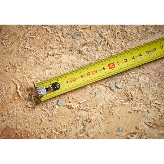 STANLEY STHT37233 yellow tape measure on wood with sawdust, close-up photography.